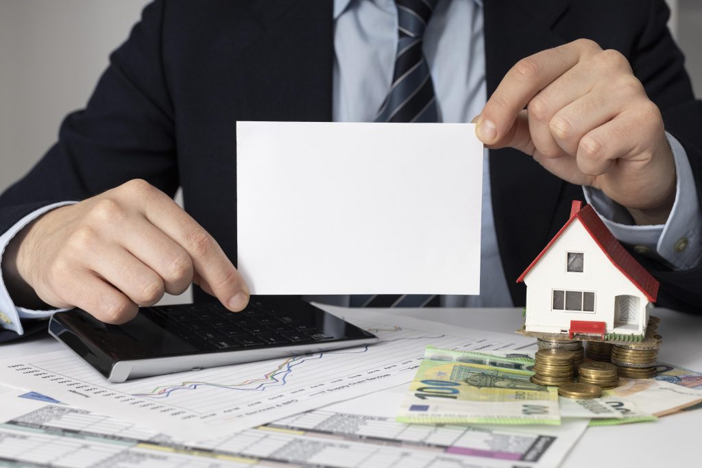 businessman-holding-empty-card-miniature-house-scaled
