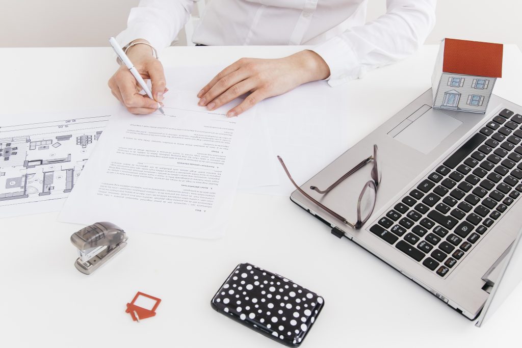 overhead-view-human-hand-putting-signature-official-paper-office-scaled